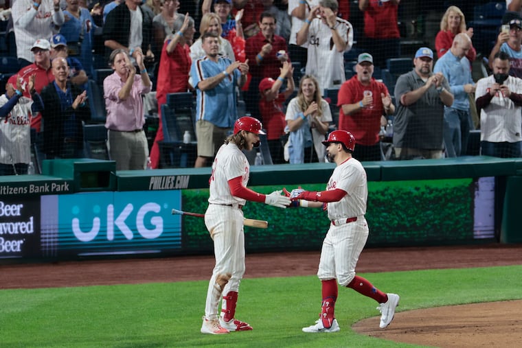 Kyle Schwarber (right) is greeted by Alec Bohm after his solo home run in the third inning against the Marlins. Schwarber homered twice and now has 56 this season.