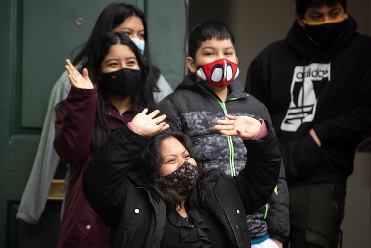 Carmela Apolonio Hernandez waves to the media, as her children stand behind her during a departure ceremony at the Germantown Mennonite Church. After three years and three months, the family is leaving sanctuary.