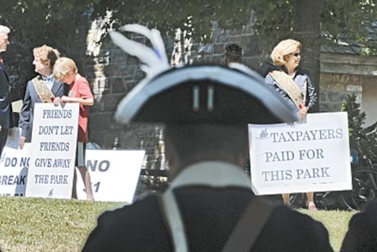Members of a nonprofit have declared war on a proposed bill to turn over a section of Washington Crossing Historic Park to another nonprofit. Above, members of the Crossing Legacy Foundation protested at the reopening of the visitor center there during ceremonies Thursday. (CLEM MURRAY / Staff Photographer)