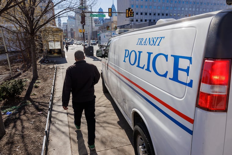 Pedestrian walking past SEPTA Transit police van.