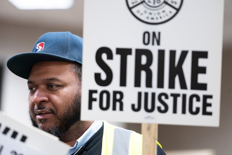 Otis Barnes, a SEPTA bus operator, picks up a picket sign at the TWU Local 234 hall in Northern Liberties Monday. Employees are preparing for a strike that could come as early as Friday morning.
