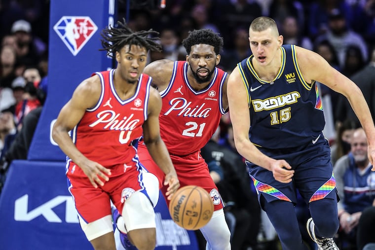 Sixers Tyrese Maxey, Joel Embiid watch the loose ball with Nuggets Nikola Jokic during the 1st quarter at the Wells Fargo Center in Philadelphia, Monday, March 14, 2022.