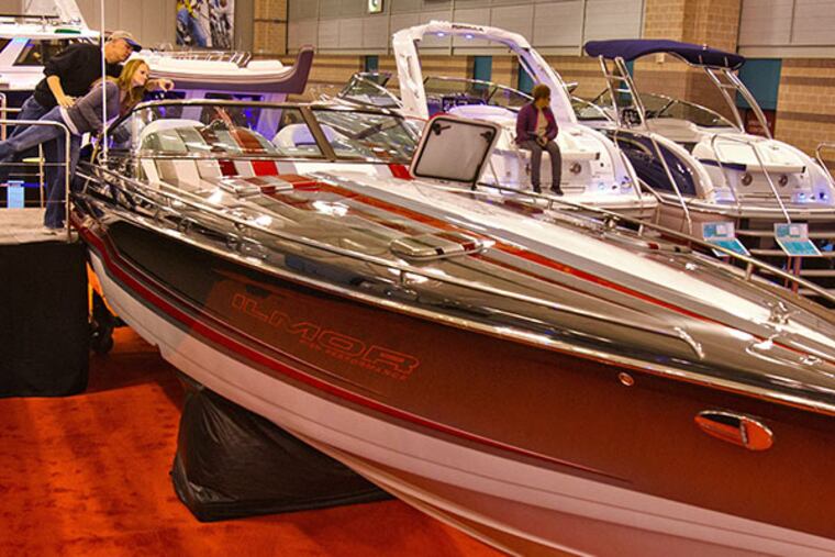 Valerie Cappetti and John K. Honer, Commodore of the Camden City Yacht Club, lean in for a look at the high performance Formula 353 Fast Tech at the Progressive Insurance Atlantic City Boat Show, Atlantic City Convention Center, February 5, 2014. ( DAVID M WARREN / Staff Photographer )