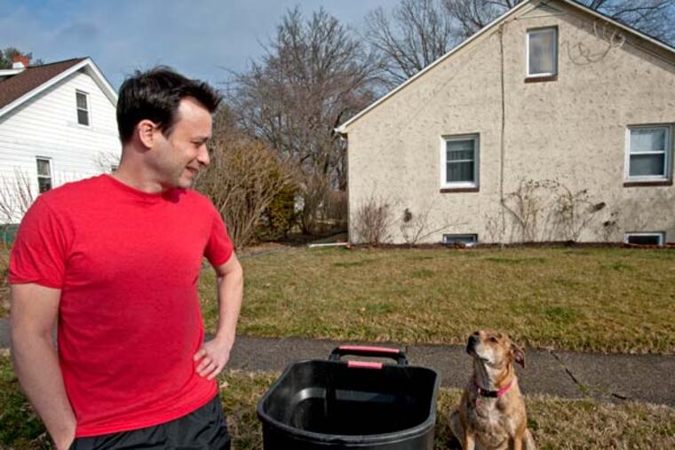 In Glassboro, NJ, Robert Hess and his dog Rosie stand next to a bin he leaves just outside his house for the use of Rowan students.( APRIL SAUL / Staff Photographer )