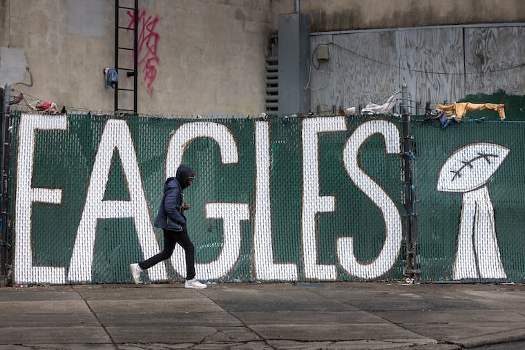 Someone walks past an Eagles sign in Kensington.