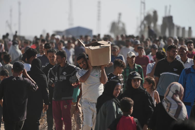 Palestinians carry boxes containing food and humanitarian aid packages delivered by the Gaza Humanitarian Foundation, a U.S.-backed organization approved by Israel, in Rafah, southern Gaza Strip, on Tuesday, May 27, 2025.