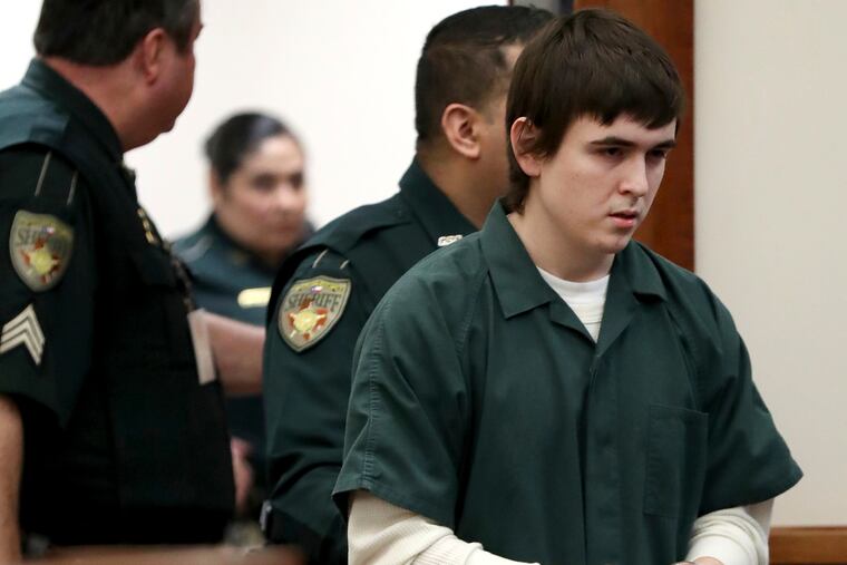 FILE - In this Feb. 25, 2019, file photo Dimitrios Pagourtzis, the Santa Fe High School student accused of killing 10 people in a May 18 shooting at the high school, is escorted by Galveston County Sheriff's Office deputies into the jury assembly room for a change of venue hearing at the Galveston County Courthouse in Galveston, Texas. (Jennifer Reynolds / The Galveston County Daily News via AP, Pool, File)
