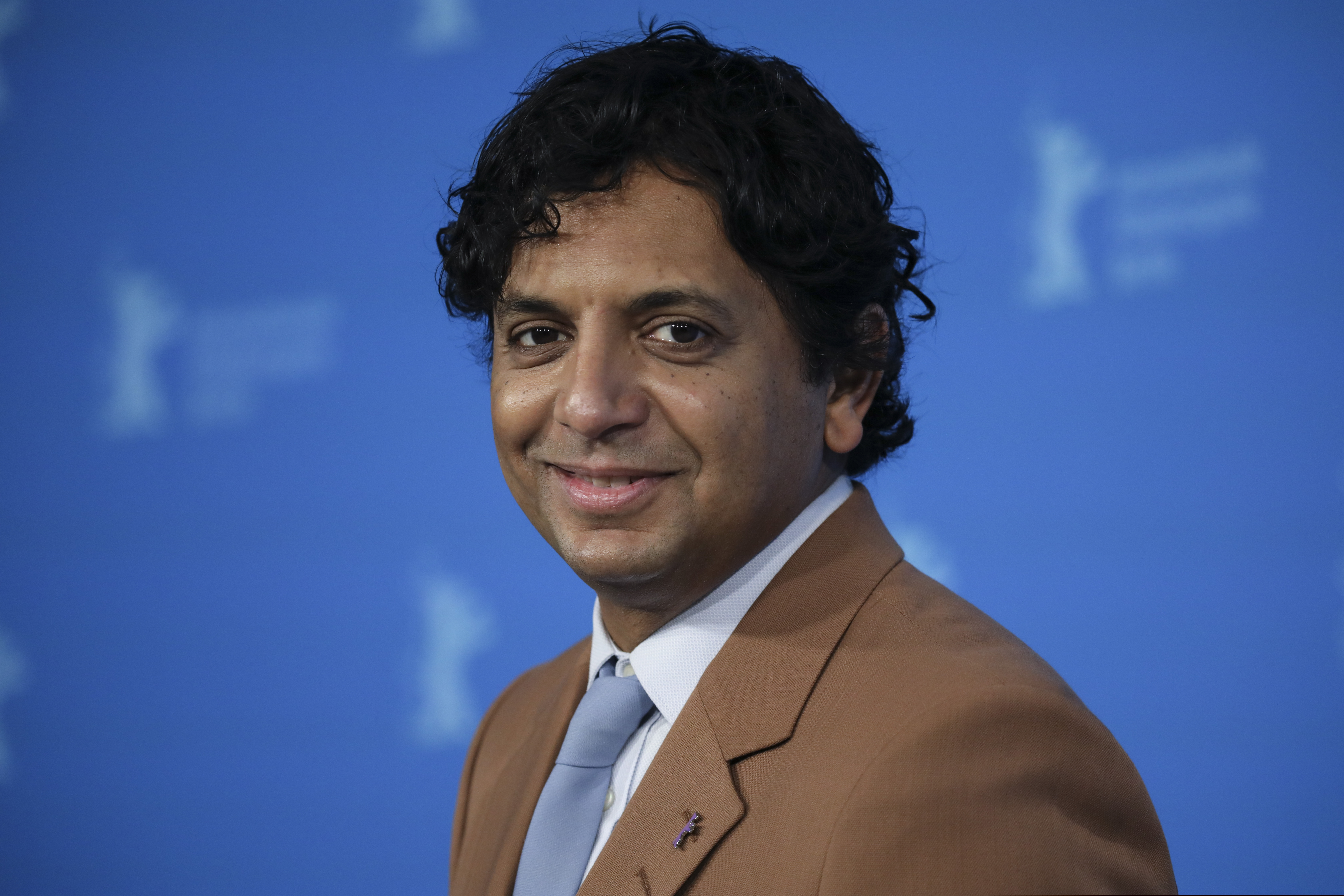M. Night Shyamalan poses for photographers at the International Film Festival Berlin "Berlinale," in Berlin, on Feb. 10, 2022. (Photo by Vianney Le Caer/Invision/AP)