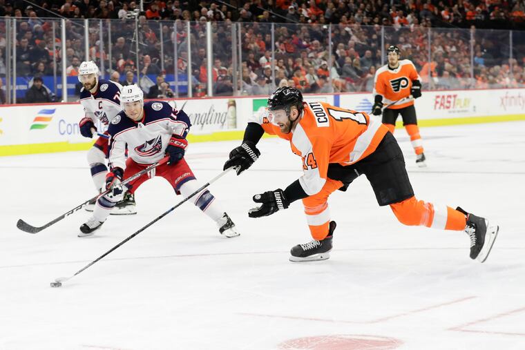 Flyers center Sean Couturier (14) taking the puck from the Columbus Blue Jackets' Cam Atkinson early in the season.