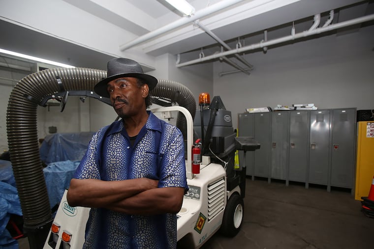 Charles Johnson in the Passyunk Avenue Revitalization Corp. garage in front of a street cleaning machine. ( STEPHANIE AARONSON / Staff Photographer )