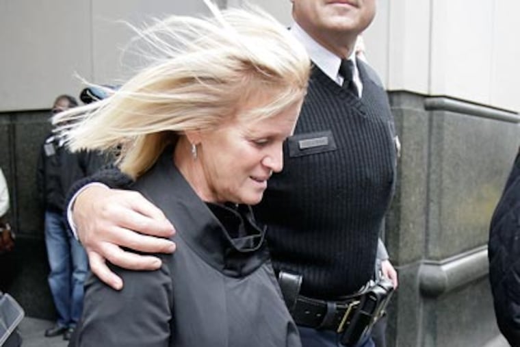 Judy Cassidy, is escorted out of the Criminal Justice Center during a lunch break in the trail of John Lewis, who was found guily of killing her husband, Officer Chuck Cassidy. ( David Maialetti / Staff Photographer )