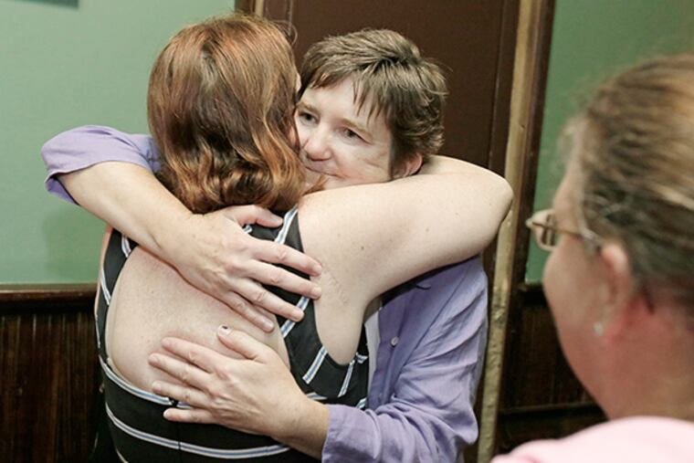 People lined up to hug Margie Winters (facing camera) after meeting at Jacks Firehouse on July 8, 2015. ( ELIZABETH ROBERTSON / Staff Photographer )