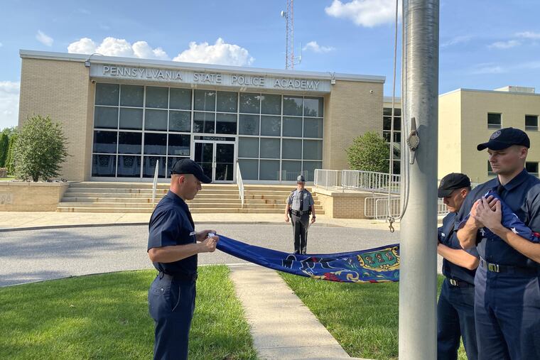 Three Pennsylvania State Police trooper cadets fold flags as a trooper watches at the State Police training academy in Hershey, Pa. Nearly 93 percent of the department's troopers and senior officials are white in a state where close to 25 percent of the population is not.