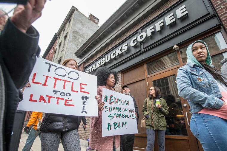 Soren McClay, left, and her stepmother, Donn T, right, hold up signs of protest during the local Black Lives Matter demonstration in front of the Starbucks at 18th and Spruce on Sunday April 15, 2018. Protesters demonstrated outside the Starbucks at the center of this storm Sunday, and plan to return Monday at peak time: 7 to 10 a.m. Organizers are calling for the employee who called police and the arresting officers to be fired<br/>
MICHAEL BRYANT /Staff Photographer