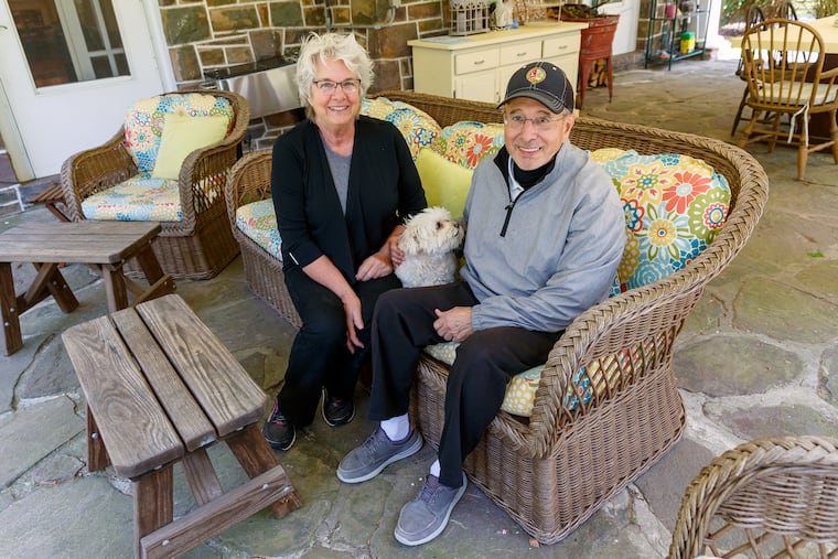 Leslie and Tom Sodano with their dog Lulu, on the porch of their home in Tobyhanna. They have a view of Lake Naomi, across the road. Leslie made the colorful seat cushions.
