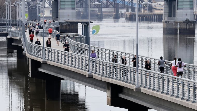 Joggers and walkers move along the Schuylkill Banks Boardwalk on Sunday, March 8, 2026.