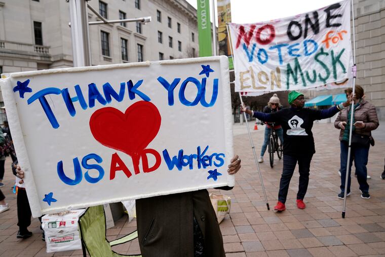 Supporters cheer USAID workers as they carry their personal belongings after retrieving them from the agency's headquarters in Washington last month.