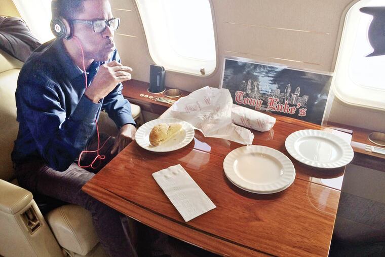 Chris Rock chows down on a Tony Luke's cheesesteak on his private plane after promoting his film 'Top Five.'