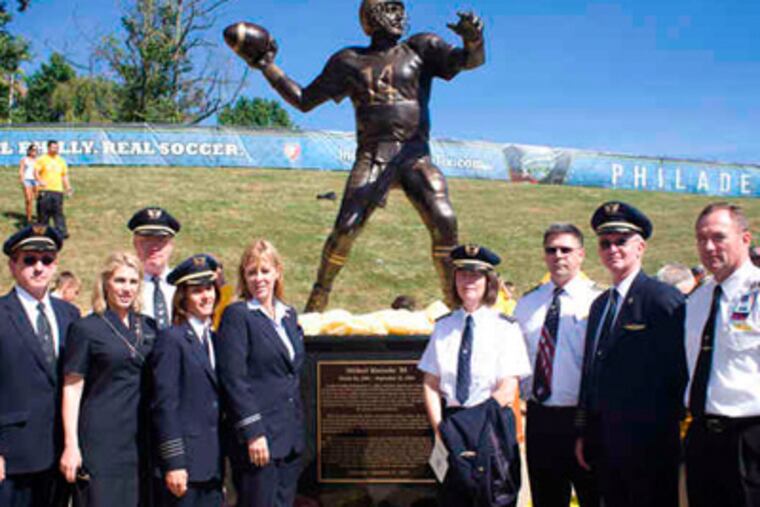 United and Continental Airlines pilots and crew, all friends of Mike Horrocks', stand by his statue at Farrell Stadium. (Ed Hille / Staff Photographer)