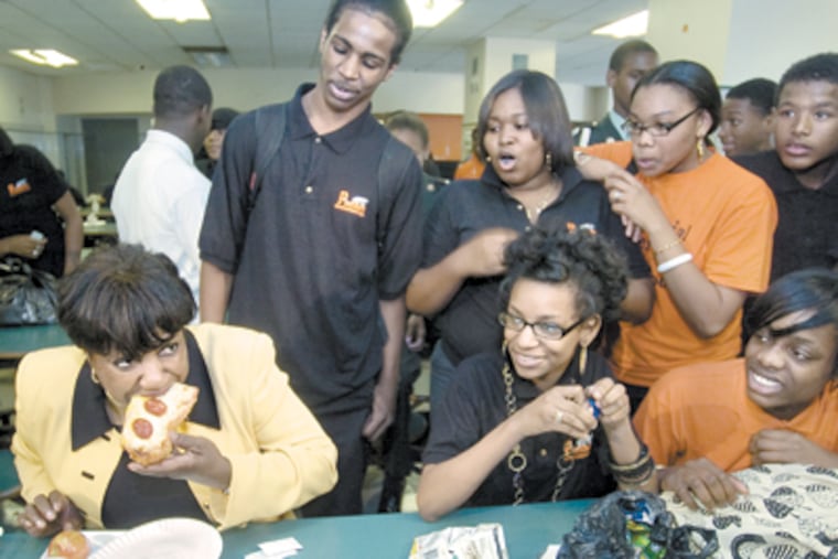 Awaiting the verdict, Overbrook High students watch as new schools chief Arlene Ackerman takes a bite of cafeteria pizza on her visit to the school. She said her lunch was "just great." (Clem Murray/Inquirer)