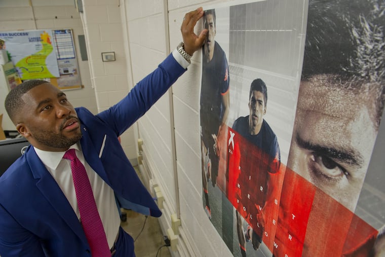 Sports marketing business teacher Howard Brown hangs an inspirational sports poster in his Northeast High School classroom as he prepares for this fall semester at the Philadelphia school on Friday August 24, 2018. Brown, a former exec at Goldman Sachs, made more money than he knew what to do with. But after living the high life in NYC he realized that money isn't everything. Now, he's back home in Philly and about to begin his second year teaching 11th and 12th graders.