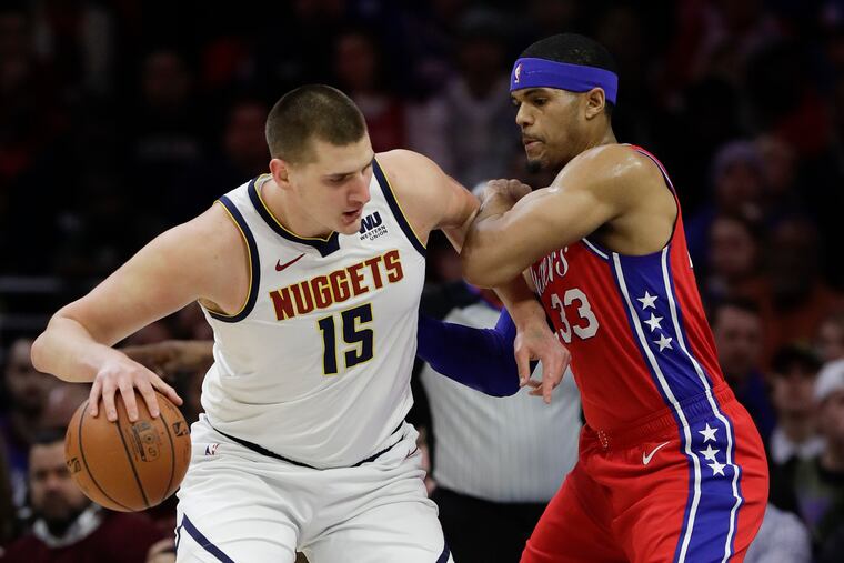 Sixers forward Tobias Harris defends Denver Nuggets center Nikola Jokic in a game last season.