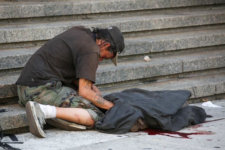 A dog lays dead on the sidewalk near 1600 Arch St. in Center City Philadelphia after a sheriff discharged his weapon twice into the dog early Monday, July 16, 2018. The sheriff's deputy was trying to break up a fight when the dog attacked the deputy.