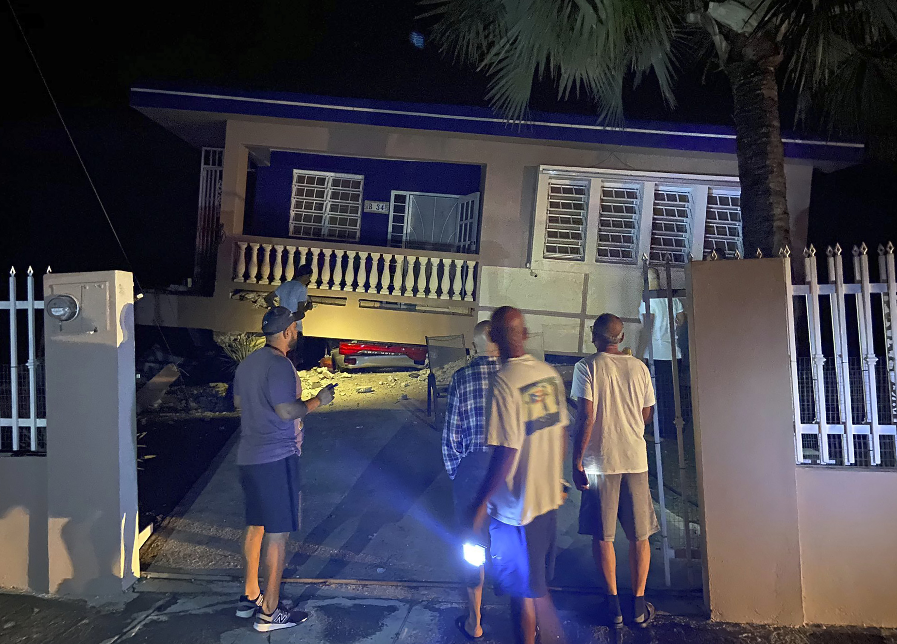 A collapsed building with car crushed underneath, following an earthquake in Yauco, Puerto Rico, on Tuesday. All the occupants of the home are reported to be uninjured.