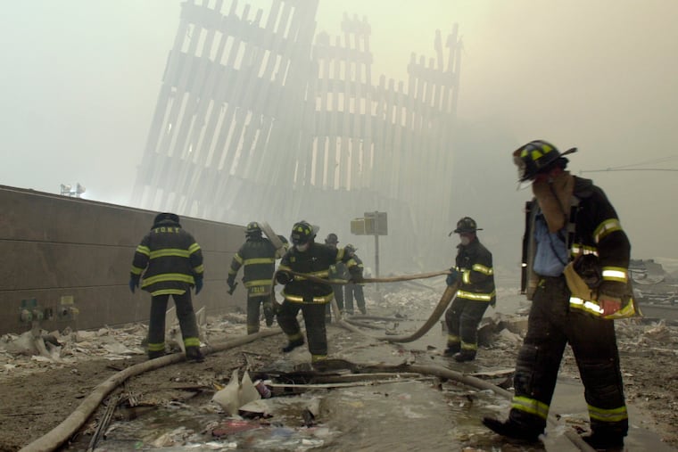 Firefighters work beneath the destroyed mullions, the vertical struts that once faced the soaring outer walls of the World Trade Center towers, after a terrorist attack in New York on Sept. 11, 2001.