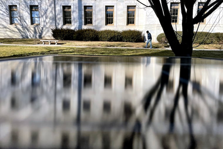 The Delaware County Courthouse in Media is reflected in a solar panel atop one of the borough’s on-street parking kiosks along Front Street.