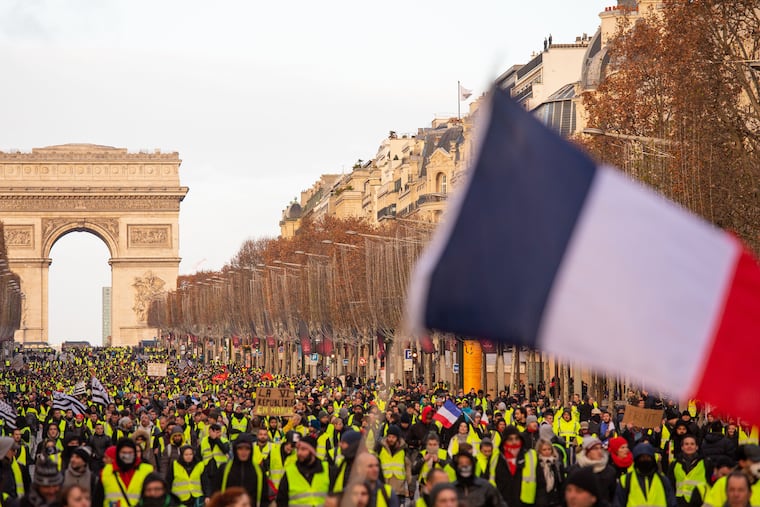 A massive crowd walks along the Champs Elysees during anti-government demonstrations on Dec. 8, 2018 in Paris. President Emmanuel Macron promised a monthly rise in France's minimum wage among measures aimed at placating the Yellow Vest protest movement. (Omer Messinger/Zuma Press/TNS)