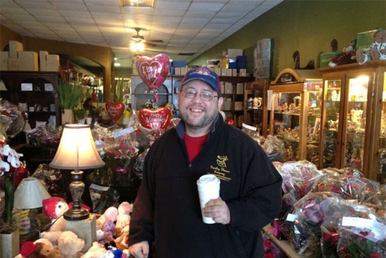 Jeffrey Sklute, owner of the Yardley Flower Co., fuels himself with coffee to get ready for a late Thursday night preparing Valentine's Day orders. (Sulaiman Abdur-Rahman / Staff)
