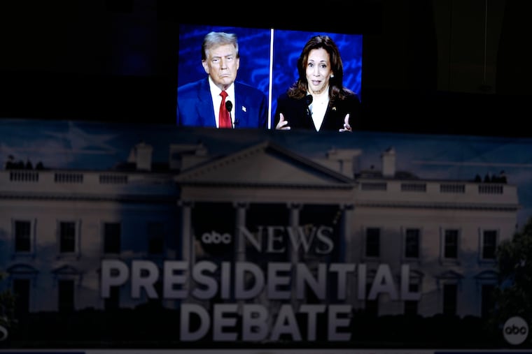 A presidential debate between Republican presidential nominee former President Donald Trump (on screen at left) and Democratic presidential nominee Vice President Kamala Harris (right) is seen from the spin room Tuesday in Philadelphia.