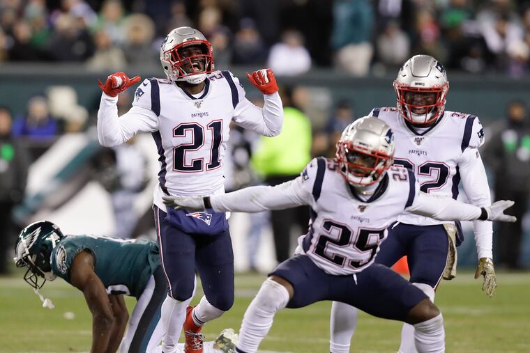 New England Patriots defensive backs Duron Harmon (21), Terrence Brooks (25) and Devin McCourty celebrate after a stop on Eagles wide receiver Nelson Agholor during the fourth-quarter on Sunday.