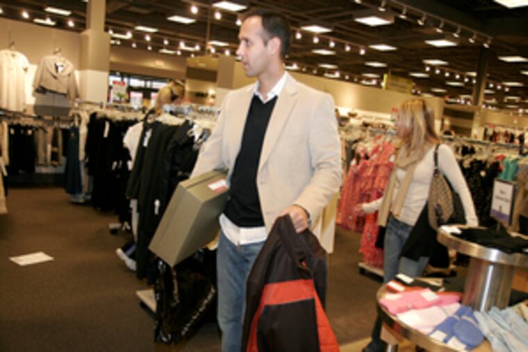 George and Eleny Zeppos, left, of Boston shop at the Neiman Marcus store at Philadelphia PremiumOutlets. Above, jeans that normally sell for $189 are priced at $89 at the Miss Sixty store. High fashion has become the focus for these outlet centers; Lim- erick's is expected to draw five million visitors in Year 1.