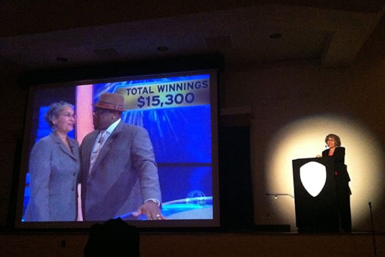 Hazel Spears (right), an assistant professor of psychology at Cheyney University, watches herself as she appears on the game show "Who Wants to be a Millionaire?" The school held a viewing party in a college auditorium Wednesday, April 30, 2014.