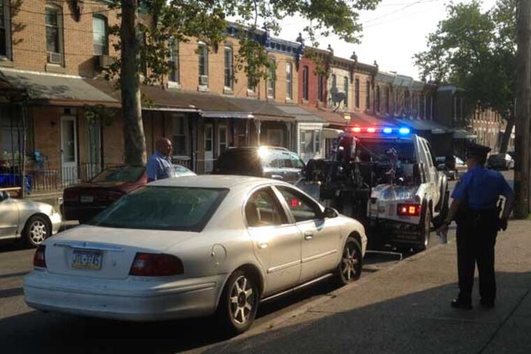 Police tow a car from the scene of a quadruple shooting in Nicetown that left two men dead. (Emily Babay/staff)
