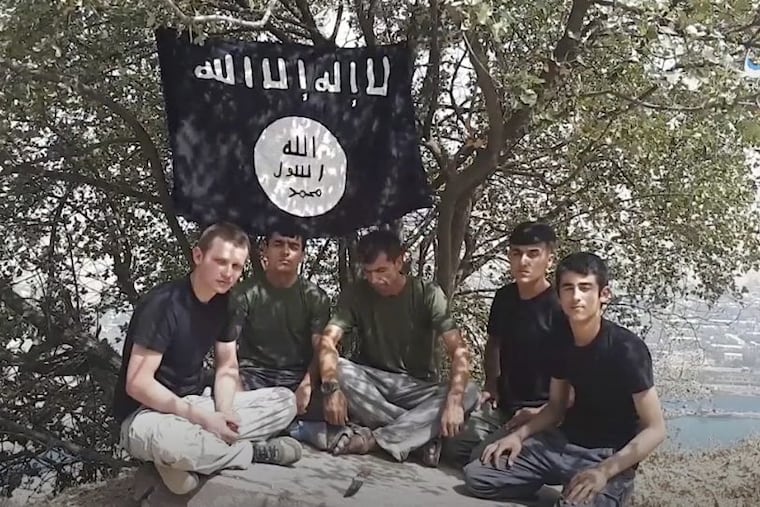 This grab taken from video, made available by Aamaq news agency of the Islamic State group, shows five men sitting on a hill against the backdrop of a black-and-white ISIS flag and declaring allegiance to IS leader Abu Bakr al-Baghdadi. The Islamic State group on Tuesday, July 31, 2018, claimed responsibility for a car-and-knife attack on Western tourists cycling in Tajikistan that killed two Americans and two Europeans.