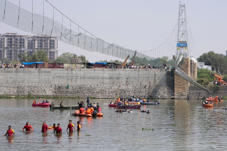 Rescuers on boats Monday search in the Machchu river next to a bridge that collapsed in Morbi, India, on Sunday evening.