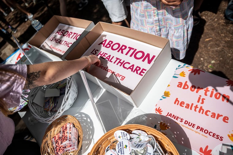 Attendees grab signs at a protest outside the Texas state Capitol on May 29, 2021, in Austin.