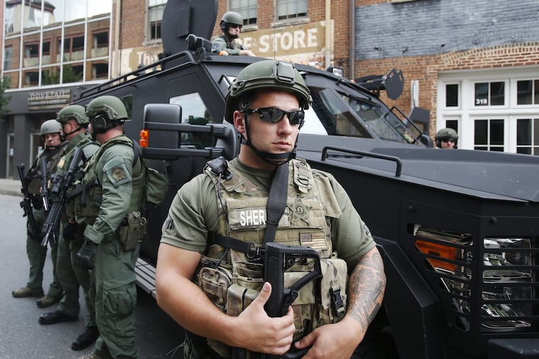 Members of a SWAT team keep an eye on demonstrators marking the one year anniversary of the Unite The Right rally in Charlottesville, Va., Sunday, Aug. 12, 2018.