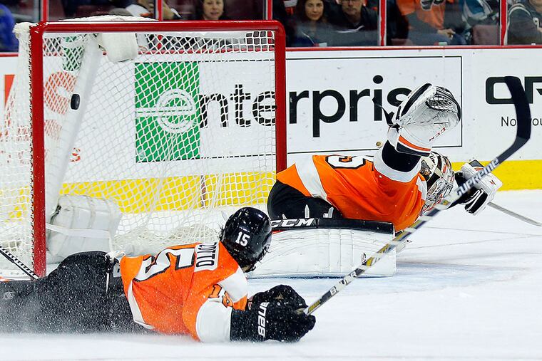 Steve Mason tries to stop the San Jose Sharks' Melker Karlsson's winning goal with Michael Del Zotto watching.
