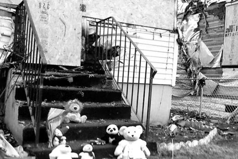 Passersby left toy tributes on the steps of the burned-out residence. A sister, 4, was among the survivors of the Thursday blaze.