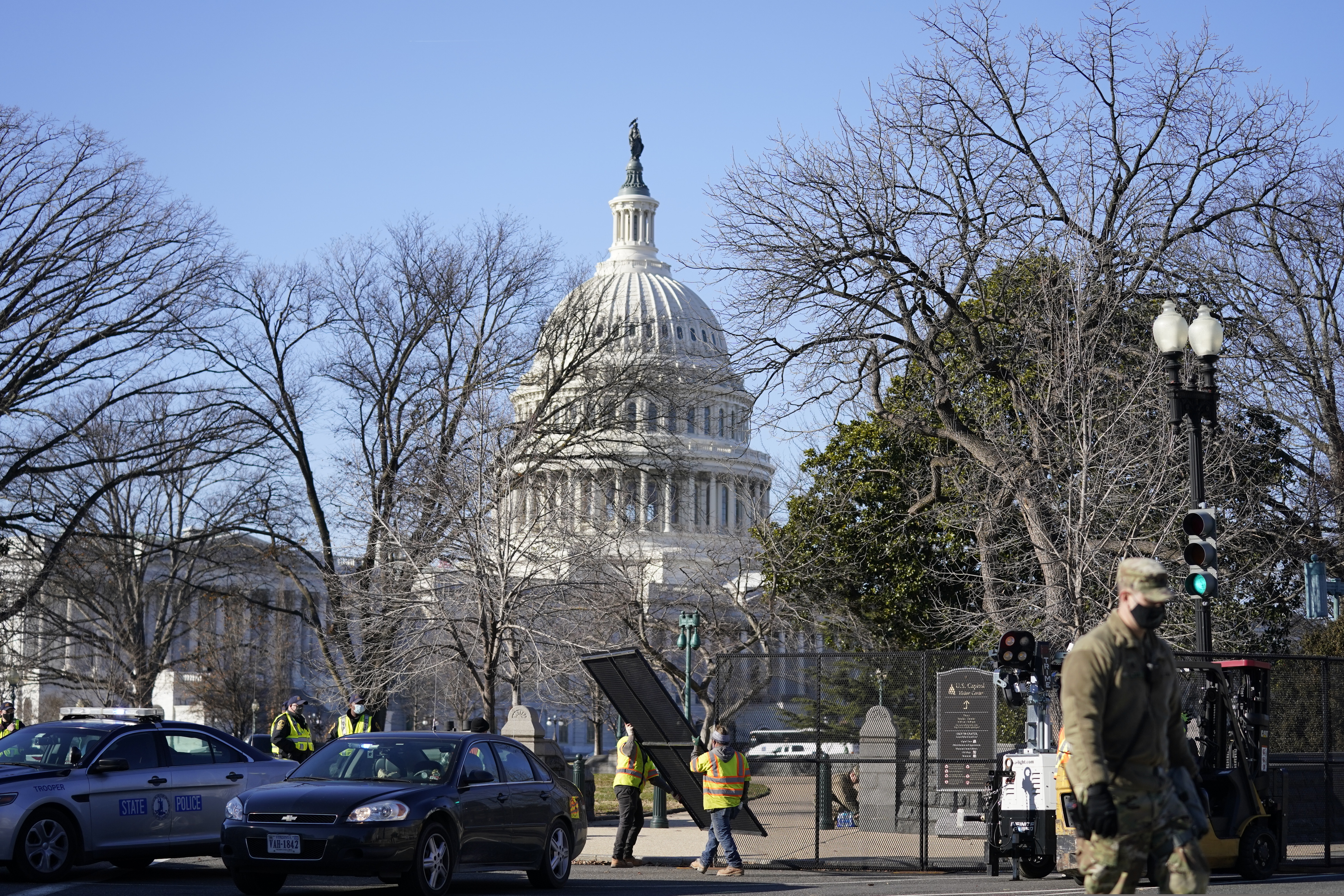 Workers install no-scale fencing around the U.S. Capitol in Washington, Thursday, Jan. 7, 2021. President-elect Joe Biden's inauguration was already going to be scaled back, but after a mob stormed the U.S. Capitol, ransacking the building and triggering chaos that stretched all the way to the Senate floor, questions began to arise about whether having a presidential ceremony on the steps of the same building could also pose serous security risk.