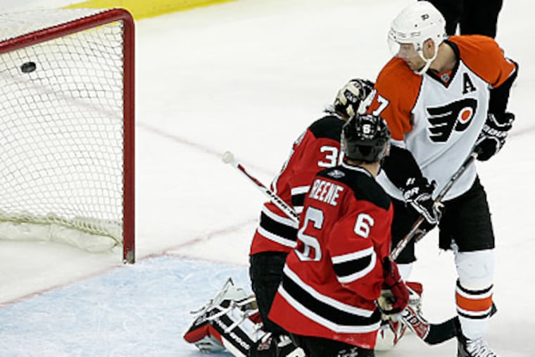 Jeff Carter watches Simon Gagne'a game-winning goal fly past Devils goalie Martin Brodeur. (Rich Schultz/AP)