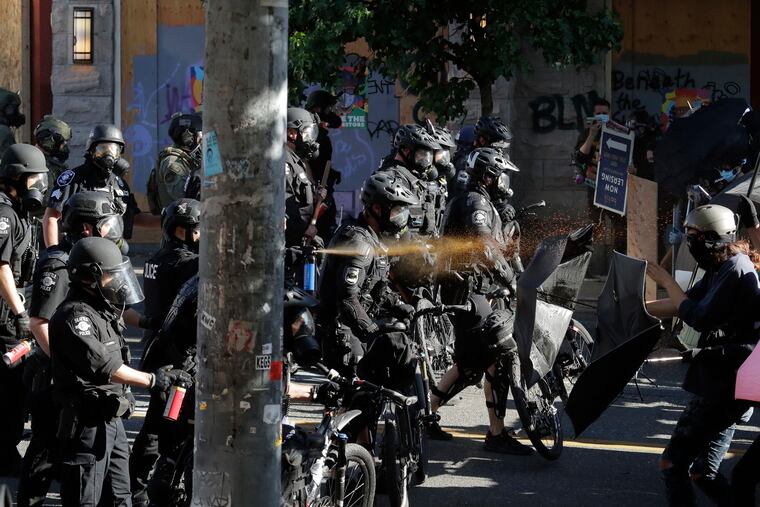 Police pepper spray protesters, Saturday, July 25, 2020, near Seattle Central Community College in Seattle. A large group of protesters were marching Saturday in Seattle in support of Black Lives Matter and against police brutality and racial injustice.
