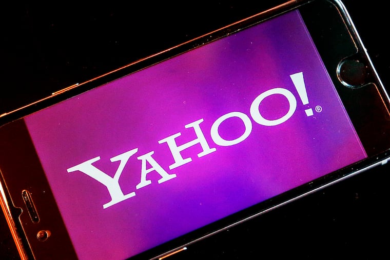 FILE - In this Dec. 15, 2016, file photo, the Yahoo logo appears on a smartphone in Frankfurt, Germany. Nearly 200 million people who had sensitive information snatched from their Yahoo accounts will receive two years of free credit-monitoring services and other potential restitution in a legal settlement valued at $117.5 million. The deal disclosed in documents filed Tuesday, April 9, 2019, revises an earlier agreement struck last October, only to be rejected by U.S. District Court Judge Lucy Koh in San Jose.