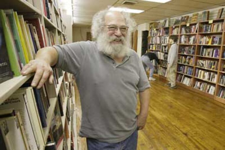 Still setting up in their new space, Larry Robin (left) takes a break while Paul Hogan and Ben Robin work in the background. (Elizabeth Robertson / Staff Photographer)