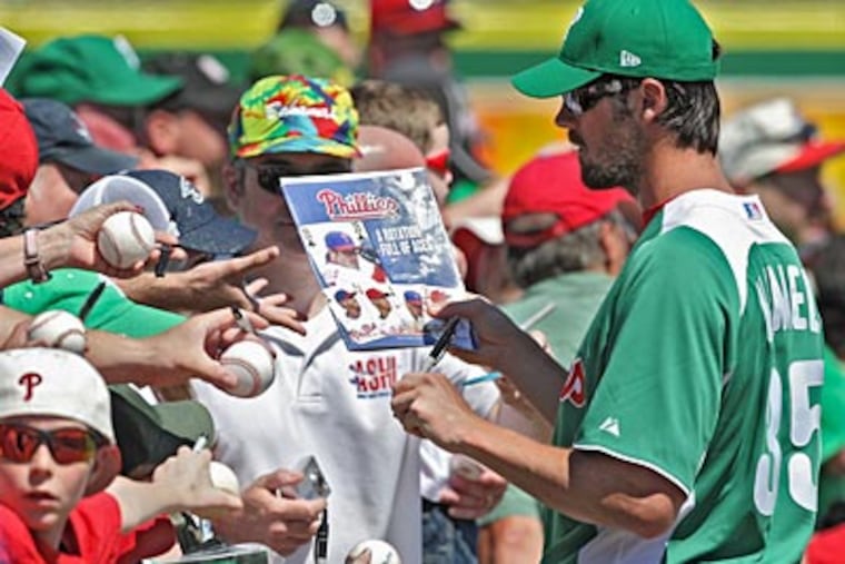 Cole Hamels signs autographs for fans at Bright House Field on Thursday. (David M Warren/Staff Photographer)