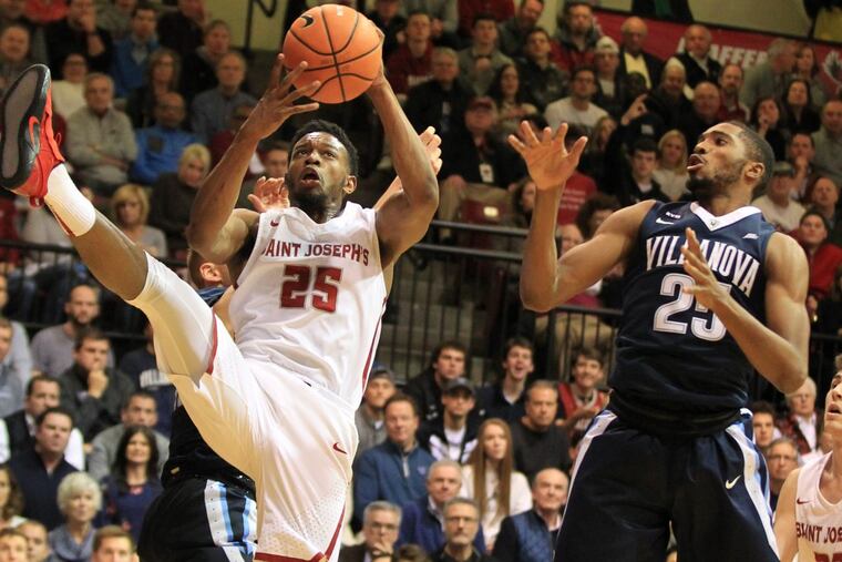 James Demery (left) of St. Joseph’s pulls down a rebound in front of Mikal Bridges, right, of Villanova during first half action at Hagan Arena on Dec. 2.